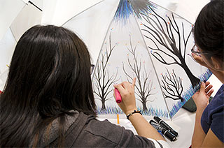 two young girls coloring umbrella